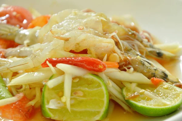 Som tum Thai picante verde papaya rematando ensalada de camarones crudos en el plato —  Fotos de Stock