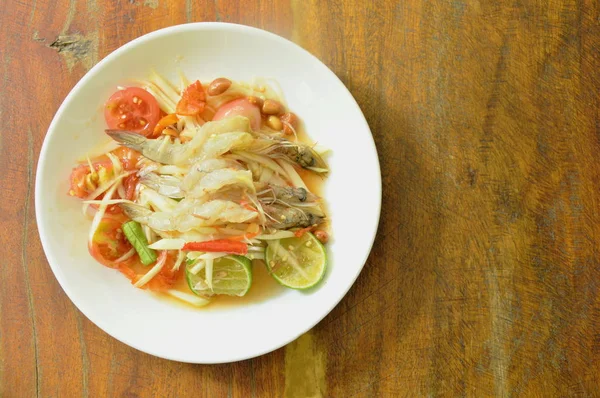 Som tum Thai kryddig grön papaya toppning råa räkor sallad på tallrik — Stockfoto