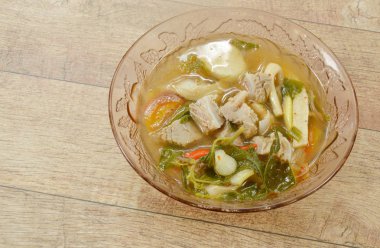 sıcak ve baharatlı domuz kemik demirhindi ve Tay otlar çorba cam kase üzerinde