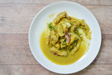 Kızarmış kalamar sarı köri ile plaka üzerine ilave edin.