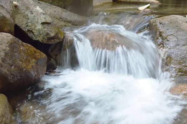 El agua corre a través del río pasa roca y piedra en el bosque —  Fotos de Stock