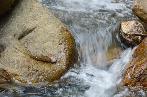 Água que flui sobre a rocha e onda salpicando no rio — Fotografia de Stock