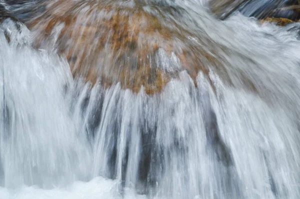 Água que flui sobre a rocha e onda salpicando no rio — Fotografia de Stock