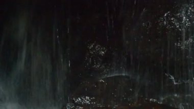 şelale orman içinde kaya arkasında mağara içinde