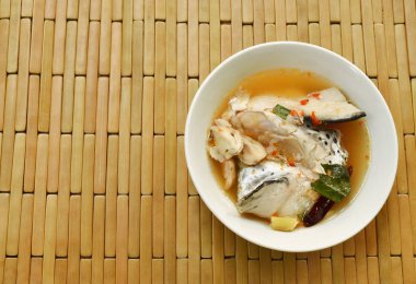 baharatlı somon balık kafası ve Tom Yum çorbası kupa bardağı taşıran damla mantar