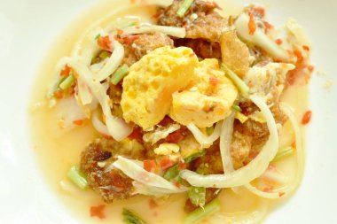  baharatlı kızarmış yumurta kesme soğan plaka üzerinde Tay salatası ile