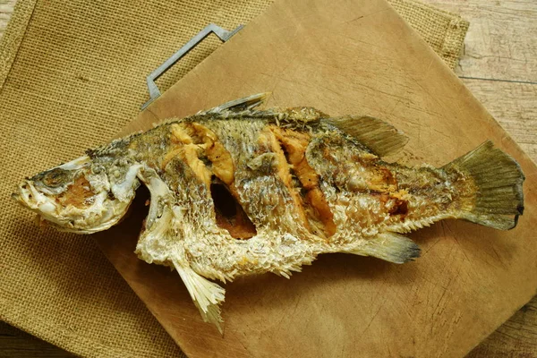 Βαθιά τηγανητό αλμυρό bass ψάρι σε ξύλινο τσεκουριά μπλοκ — Φωτογραφία Αρχείου