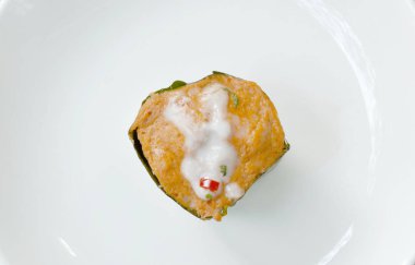  Balık buğulama ve muz yaprağı tepsisi içinde köri ezmesi.