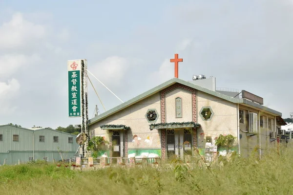 Křesťanský kostel na travních polích u duhové vesničky — Stock fotografie