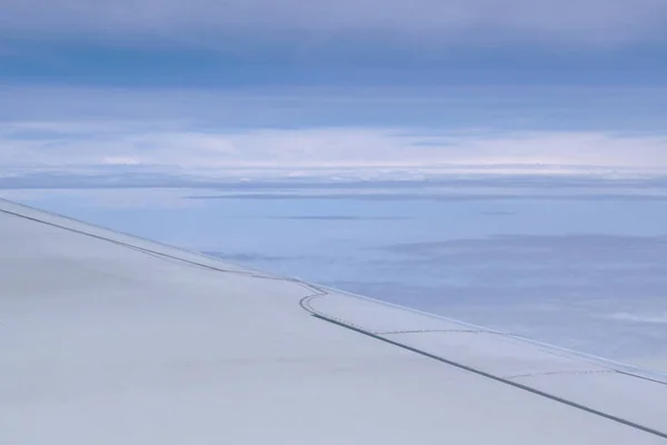 Skrzydło samolotu i chmura pływające na niebie przez ramę okna — Zdjęcie stockowe