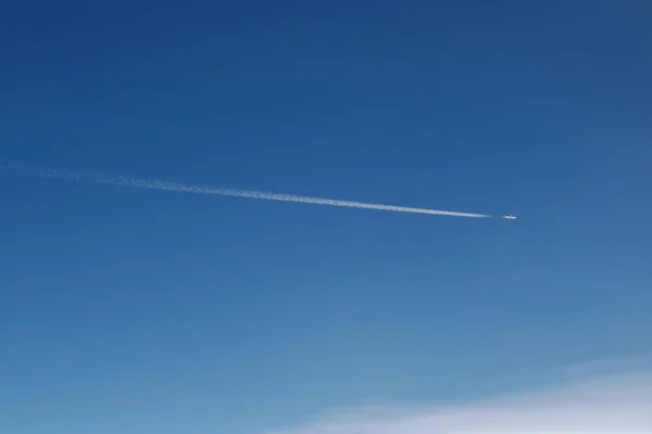 Avião voando fazer cauda de condensação no céu no dia de sol — Fotografia de Stock