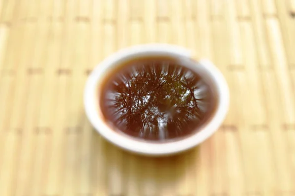 Blurry black soybean sauce in little on bamboo plate — Stock Photo, Image