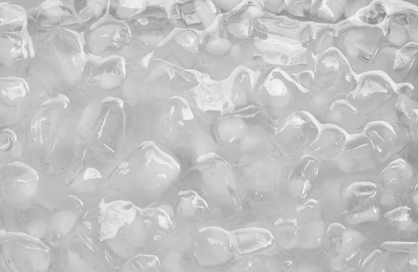 Cubo de hielo flotando en el agua en bandeja de plástico — Foto de Stock