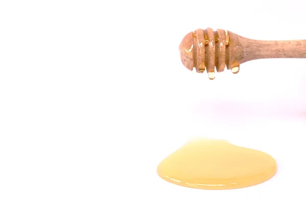Miel sobre cuchara de madera en fondo blanco — Foto de Stock