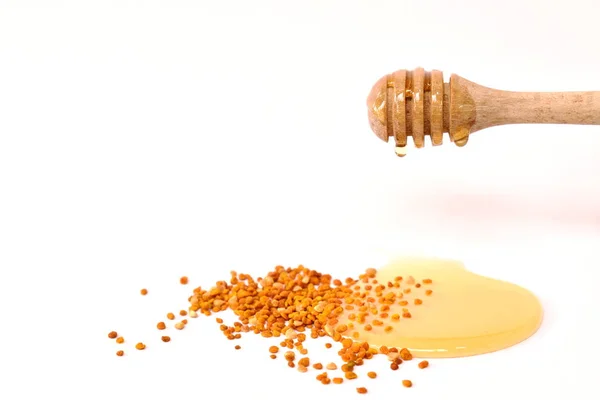 Miel en cuchara de madera y polen de abeja en fondo blanco — Foto de Stock