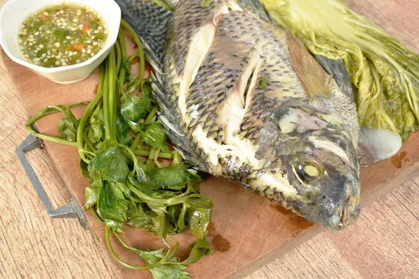 Pesce al vapore al mango con salsa piccante intingente vegetale su blocco di trito di legno — Foto Stock