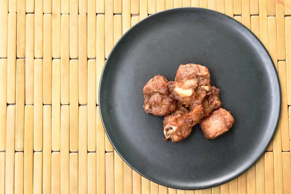 Osso di maiale fritto in fermentazione con aglio sul piatto — Foto Stock