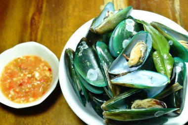  kasede baharatlı sos ile servis edilen buğulanmış midye