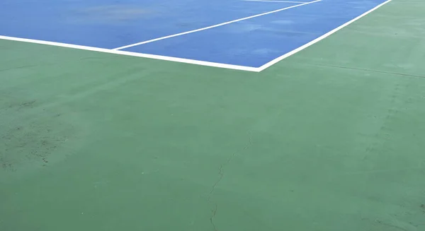 Pista de tenis azul con línea de borde blanco en el suelo verde —  Fotos de Stock