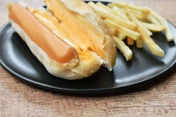 Hot dog with cheese and French fried fast food on dish — Stock Photo, Image