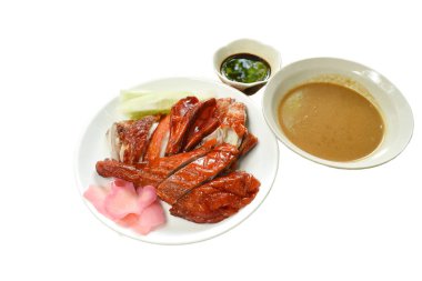 Kızarmış ördek eti ve tatlı soya sosunu tabağa bandıran zencefil turşusu.