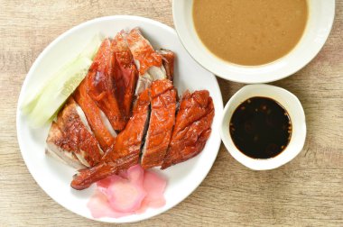  Kızarmış ördek eti ve tatlı soya sosunu tabağa bandıran zencefil turşusu.