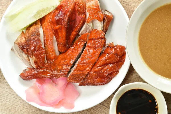  Kızarmış ördek eti ve tatlı soya sosunu tabağa bandıran zencefil turşusu.