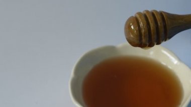 beyaz arka planda fincan ahşap kepçe damla üzerinde bal