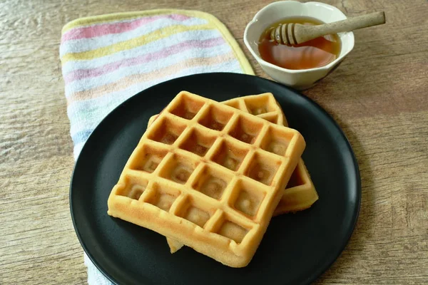 Gebackene Butterwaffel auf Teller mit Honigsirupbecher — Stockfoto