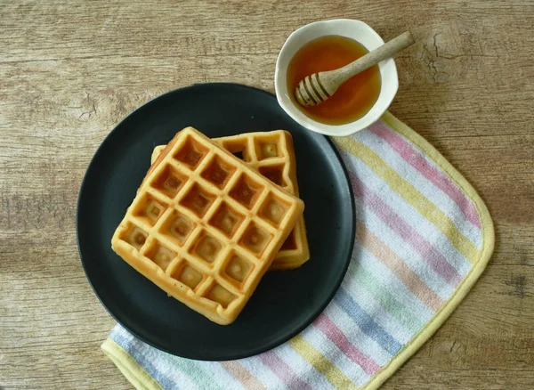 Baked butter waffle on plate with honey syrup cup — Stock Photo, Image