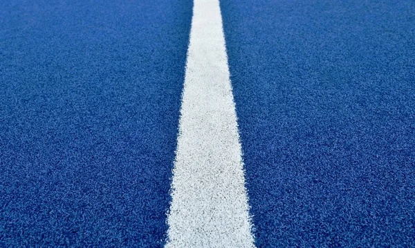 Linea bianca sulla trama tappeto erboso artificiale di calcio blu e sfondo — Foto Stock
