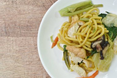  Kızarmış sarı erişteyi lahana ve vejetaryen tofu yemeğiyle karıştır.