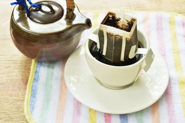 Café goutte à goutte mélangé par de l'eau chaude versant de pot en céramique sur la tasse — Photo