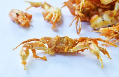  Kızarmış küçük yengeç ve beyaz zemin üzerinde un olan karides.