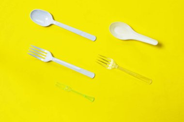  Beyaz plastik kaşık ve çatal sarı köpük tahta zemin üzerinde düzenleme