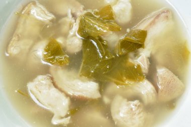 Kaynamış domuz budu ve klozetin üzerinde kova yaprağı çorbası.