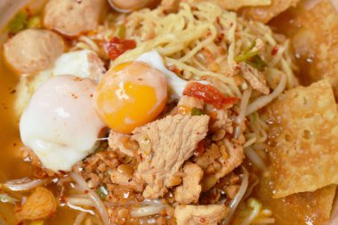  Yumurtalı şehriye domuz köftesi ve yumuşak haşlanmış yumurta sarısı tabakta baharatlı Tom çorbası.