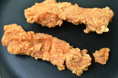 Tabakta kızarmış tavuk eti var.