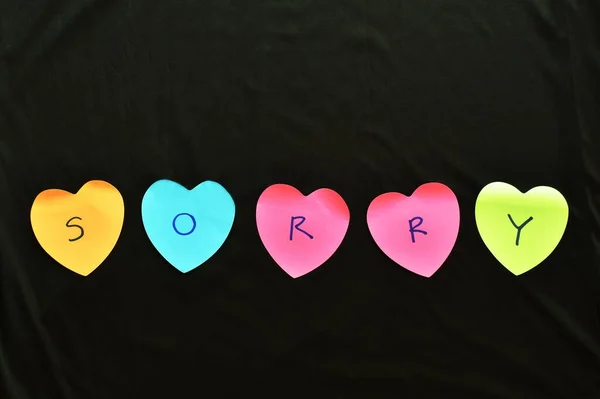 Πολύχρωμο Αυτοκόλλητο Σημείωμα Χαρτί Σχήμα Καρδιάς Γράψει Συγγνώμη Μαύρο Φόντο — Φωτογραφία Αρχείου