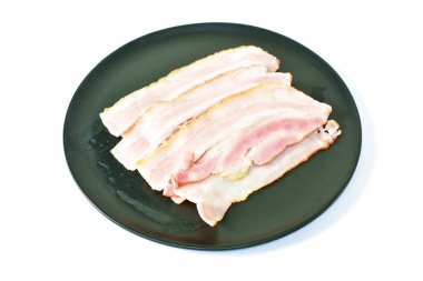  Buğulanmış domuz pastırması. Tabakta beyaz arka planda.