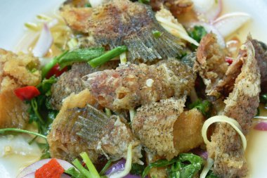 Kızarmış yılan derisi gourami baharatlı ve ekşi Tayland salatası.