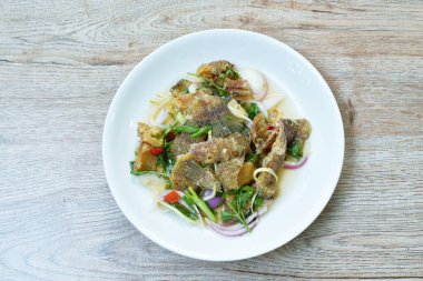 Kızarmış yılan derisi gourami baharatlı ve ekşi Tayland salatası.