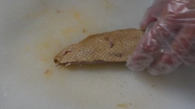 Kahverengi çorbada kaynamış ördek. Mutfak bıçağıyla dilimlenmiş. Plastik bir blokta.