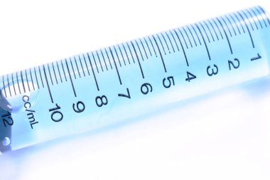 Beyaz zemin üzerinde mavi sıvı aşı düzenlenmiş şırınga tıbbi ekipmanları