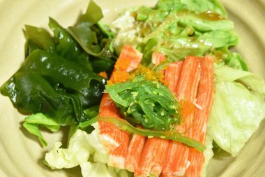 Yeşil meşe ve lahana dilimleri. Yengeç sosu. Karides yumurtalı taze deniz yosunu.