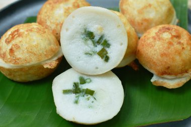 Hindistan cevizli puding pişiren Tayland tatlıları muz yaprağında taze soğan dilimleri.