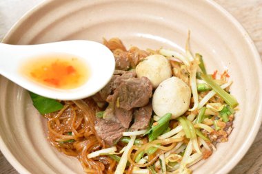 Pirinç eriştesi, domuz eti ve top, kaşık kaşık biber sirkesi sosu. 