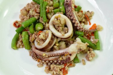 Baharatlı kırmızı biber, domuz pirzolası ve fesleğen yaprağı dilimlenmiş fasulye.