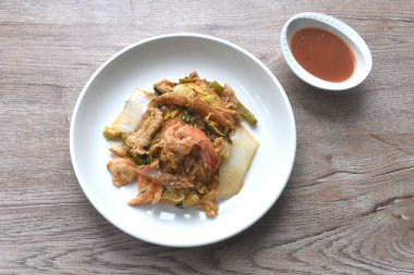 Kızarmış deniz ürünleri, tavuk ve domuz eti, çift cam erişte, sebze, yumurta sarısı, tabakta sukiyaki sosu.