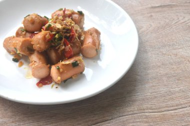 Kızarmış tuzlu sosis, sarımsak ve tabakta kırmızı biber. 